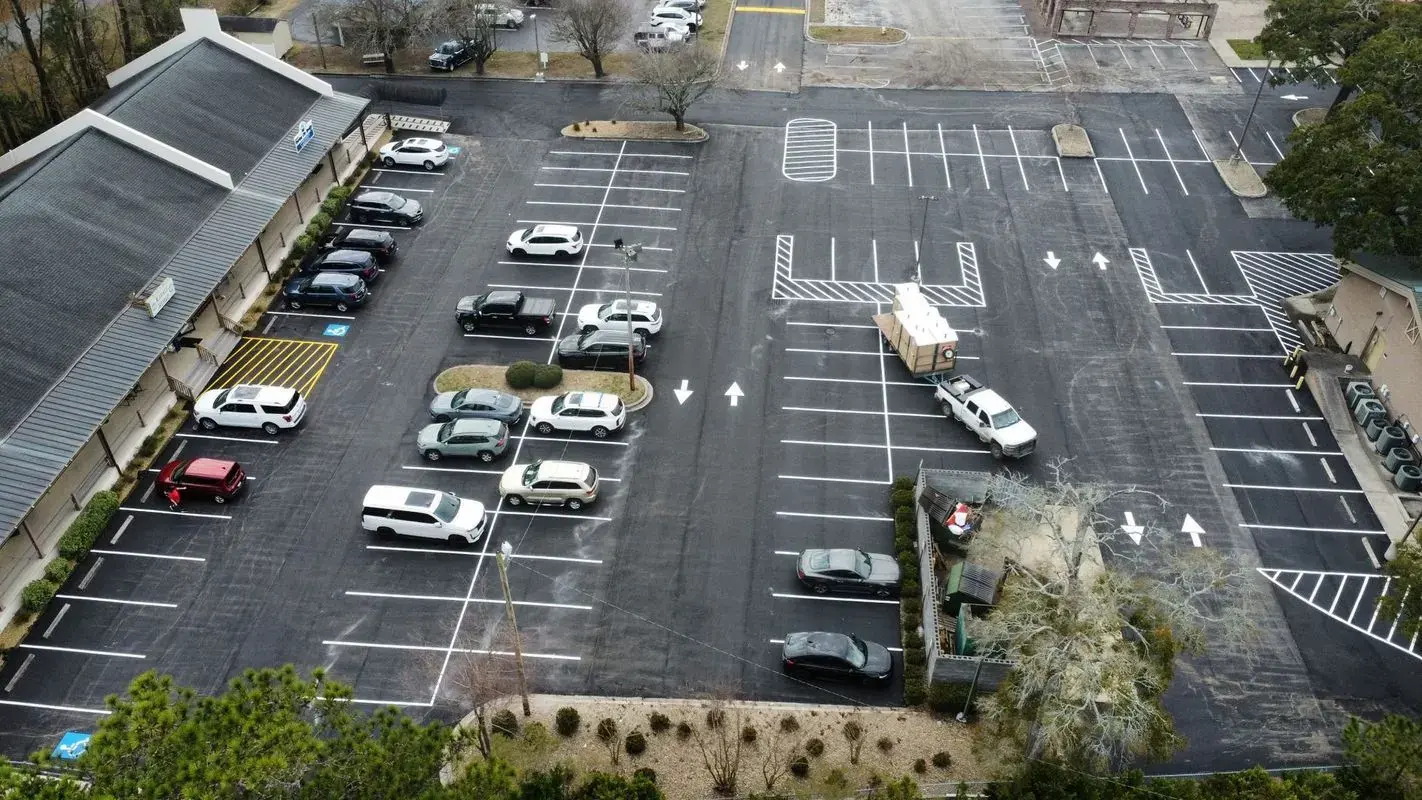 Aerial view of a newly paved and striped multi tenant shopping center parking lot