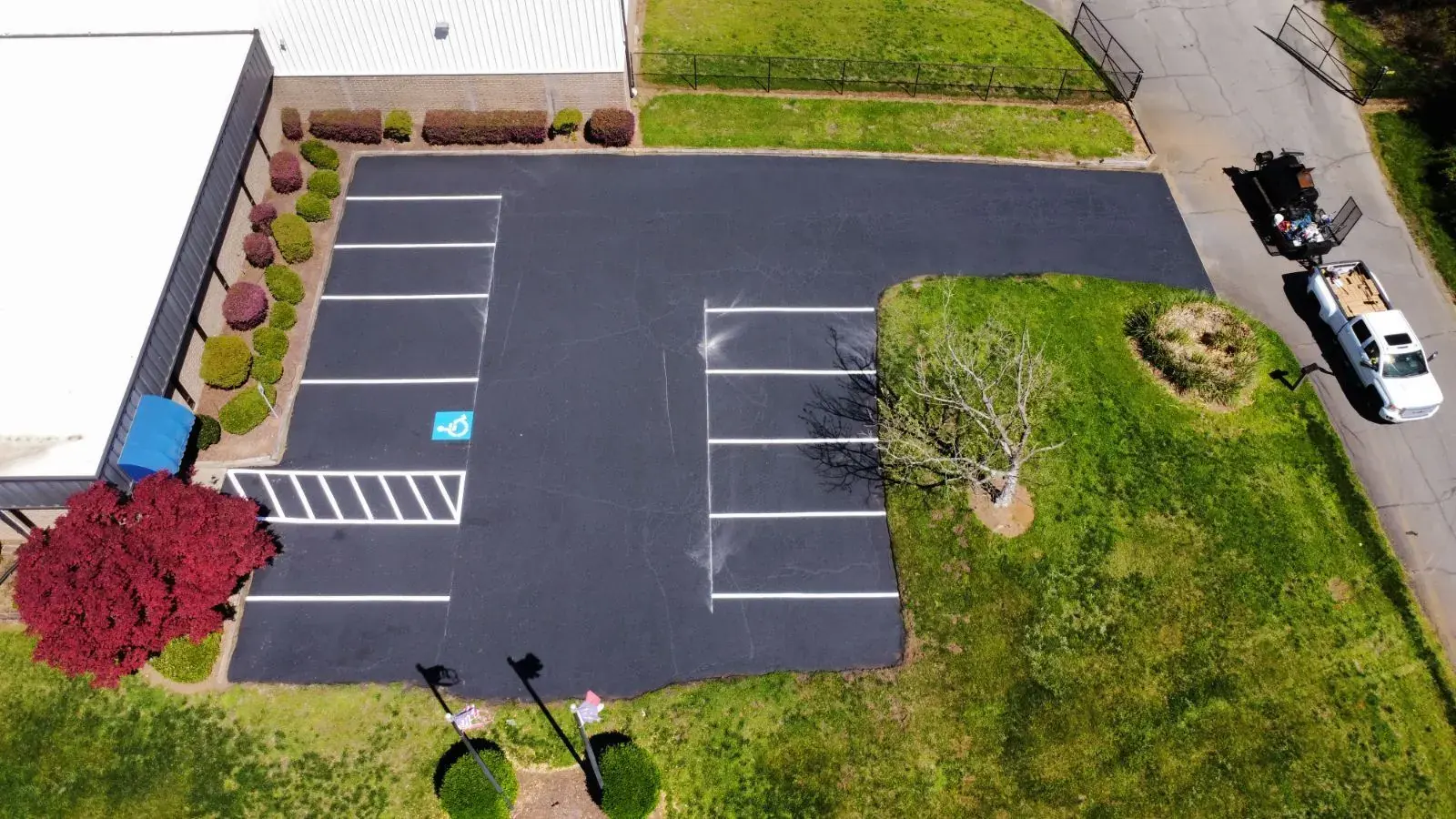 Aerial view of a rebuilt commercial parking lot with new asphalt and ADA stalls