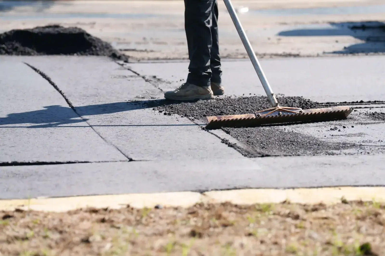Crew patching a damaged section of commercial asphalt