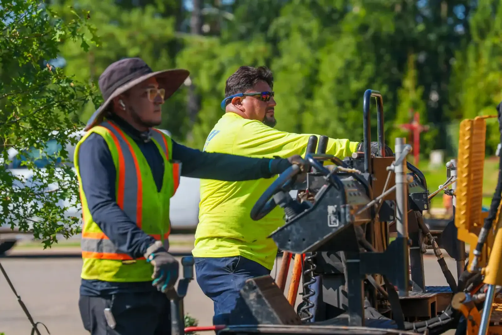 Crew operating an asphalt paver on a commercial lot