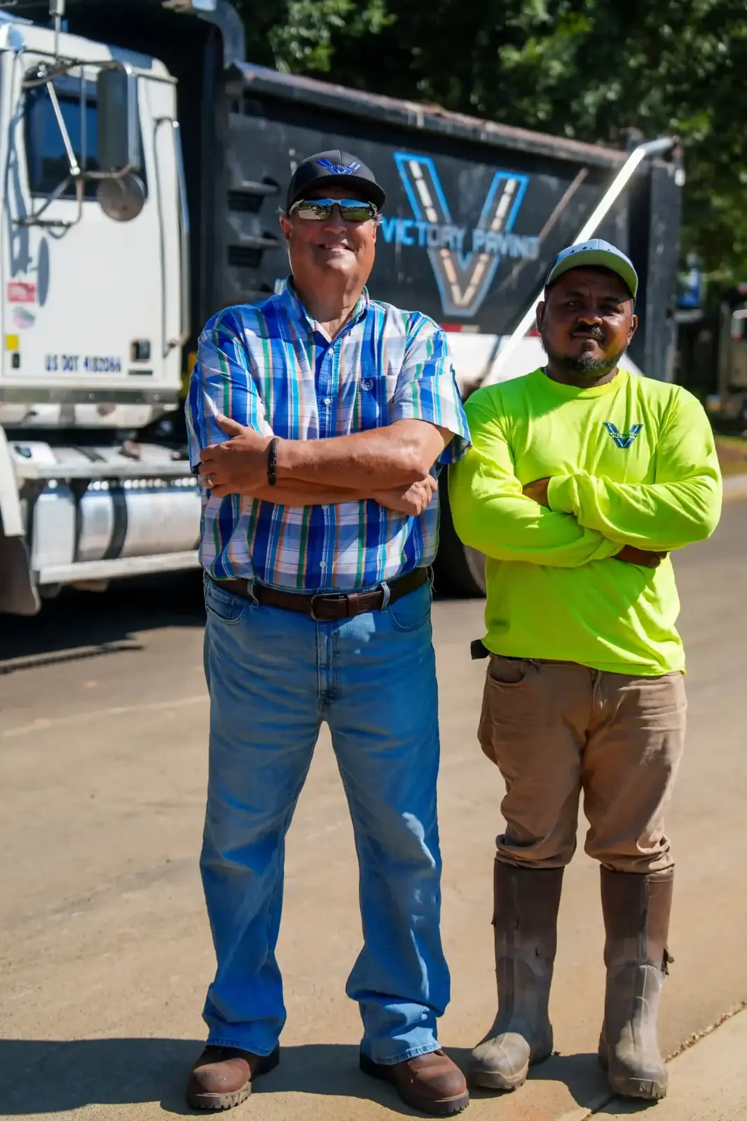 Victory Paving crew member beside a company dump truck