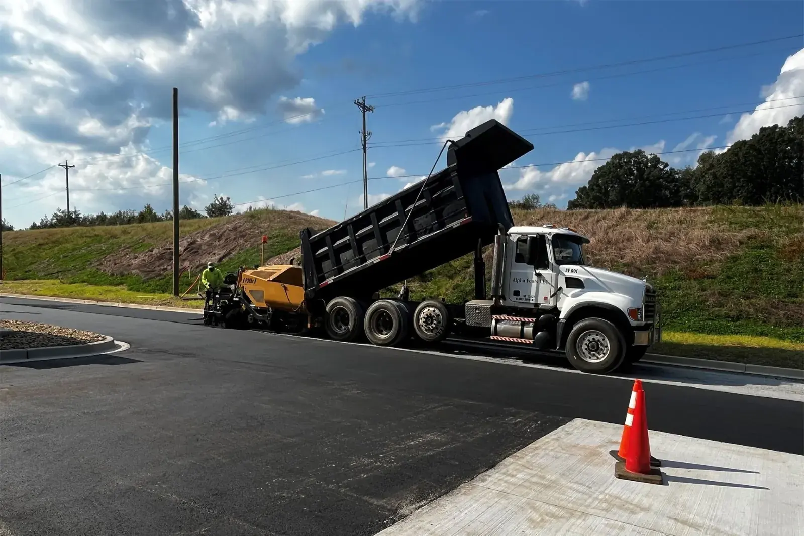 Victory Paving dump truck delivering material for grading and base preparation