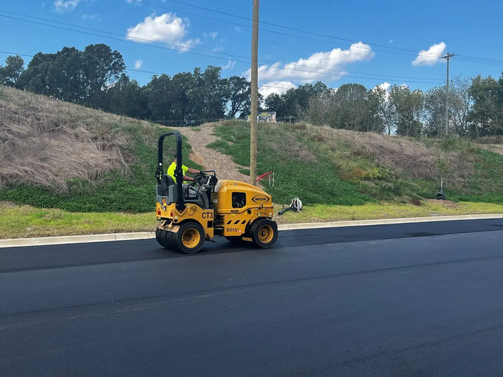 Roller compacting fresh asphalt on a commercial lot