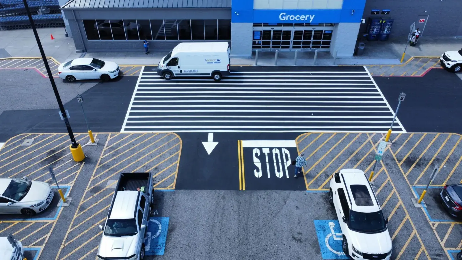 Commercial storefront entrance drive with fresh crosswalk and stop marking