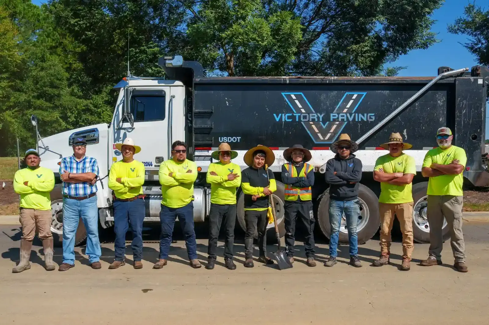 The Victory Paving crew standing in front of a company dump truck